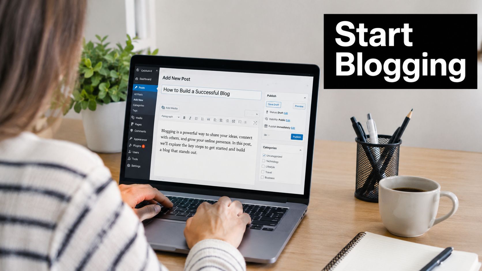 A person writing a blog post on a laptop while sitting at a desk with coffee and supplies.
